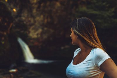 Midsection of woman looking away while standing outdoors