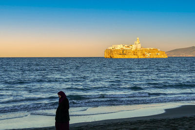 Man looking at sea against clear sky