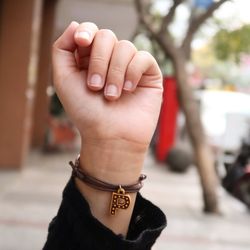 Cropped hand of woman wearing letter p bracelet