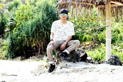 Man sitting on chair against plants