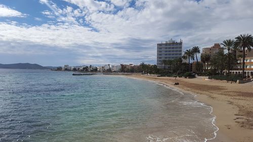 Scenic view of beach against cloudy sky