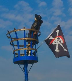 Low angle view of flags against blue sky