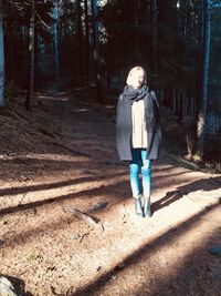 Full length of young woman walking in forest