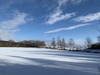 Snow covered field against sky