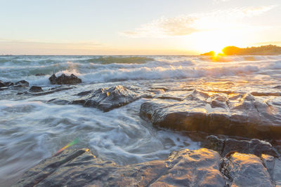 Scenic view of ocean waves at sunset