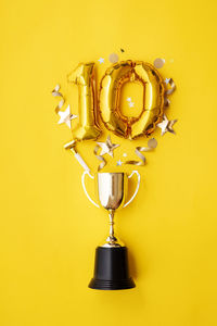 Directly above shot of illuminated light bulb against yellow background