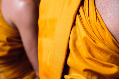 Close-up of woman standing on yellow fabric