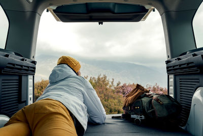 Rear view of man sitting in car