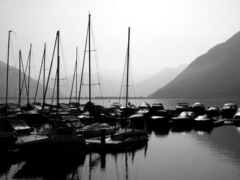 Boats moored at harbor against clear sky