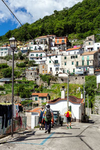 People on street amidst buildings in city