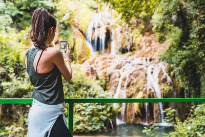 Side view of woman standing against plants