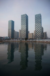 Reflection of buildings in river against sky in songdo, korea