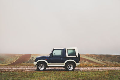 Vintage car on field against clear sky