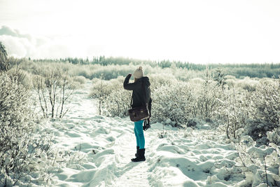 Rear view of person photographing in snow
