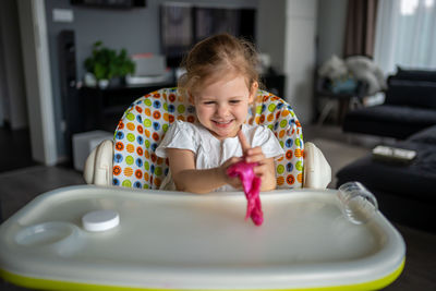 Portrait of cute boy playing with toy at home