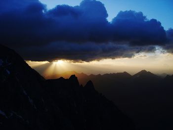 Scenic view of dramatic sky over silhouette landscape