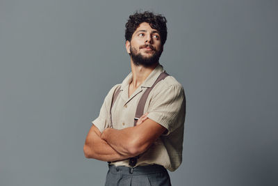 Young man standing against blue background