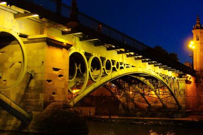 Illuminated bridge against sky at night