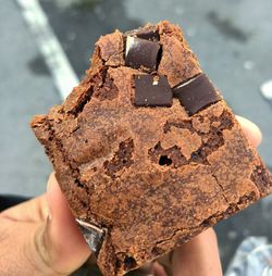 Cropped hand holding chocolate cake