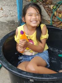 Portrait of a smiling girl sitting outdoors