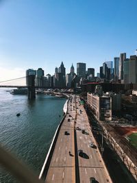 Vehicles by east river on road in city