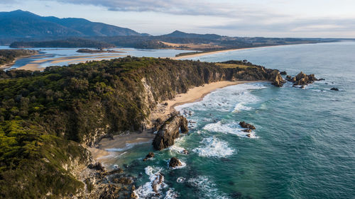 Scenic view of sea and mountains against sky