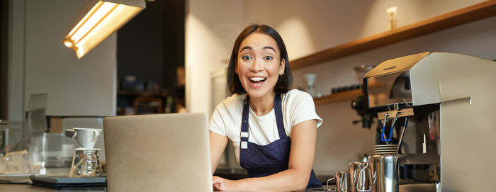 Young woman using mobile phone while sitting at home