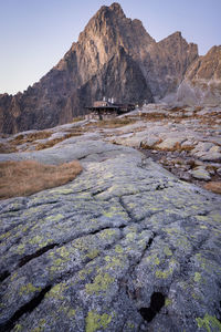 Alpine hut located under a rocky peak during early morning, vertical shot, slovakia, europe