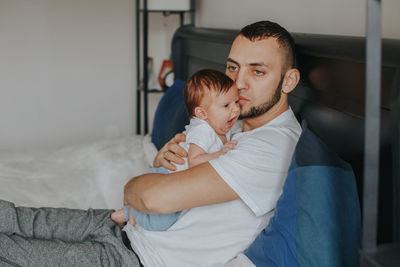 Father with daughter on bed at home