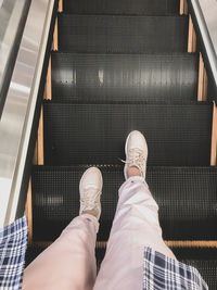 Low section of man standing on escalator