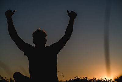 Rear view of silhouette man against sky during sunset