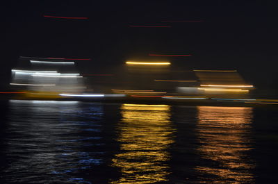 Blurred motion of boat sailing on sea at night