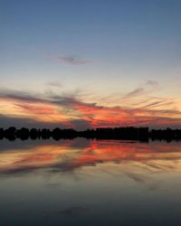 Scenic view of lake against romantic sky at sunset