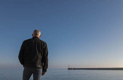Adult man against sea and sky with lighthouse in background. almeria, spain