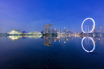 Illuminated ferris wheel in city at night