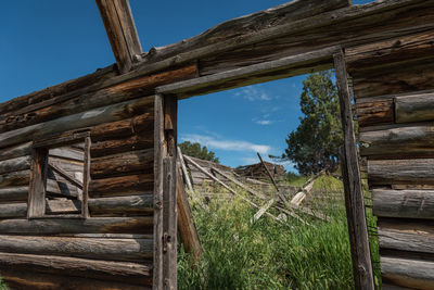 Low angle view of wooden house on field against sky