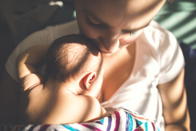 High angle view of mother with newborn daughter sitting at home