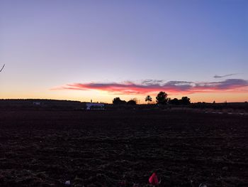 Scenic view of silhouette field against sky during sunset