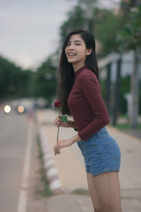 Portrait of smiling young woman standing outdoors