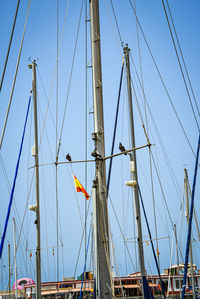 Low angle view of sailboat against clear blue sky