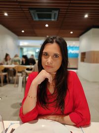 Portrait of young woman sitting on bed at home