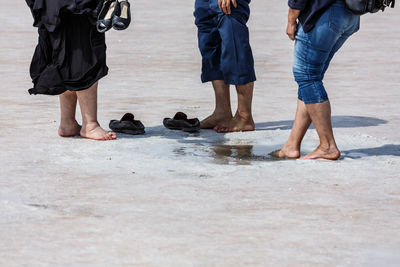 Low section of friends standing at salt lake