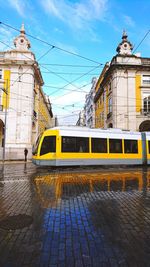 Train on street against buildings in city