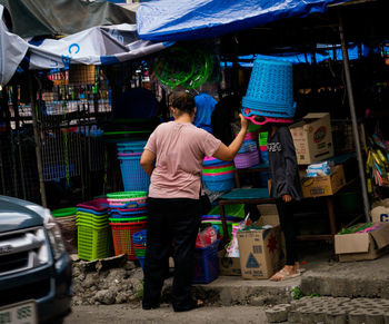 Rear view of woman standing at market stall