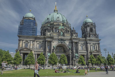 Group of people in front of cathedral against sky