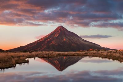 Reflection of mountains on lake against sky during sunset