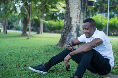 Full length of young man sitting on grass