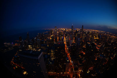 High angle view of city lit up at night