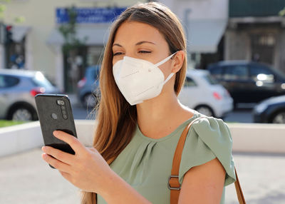 Portrait of woman using mobile phone on street