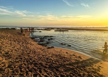 Scenic view of beach against sky during sunset